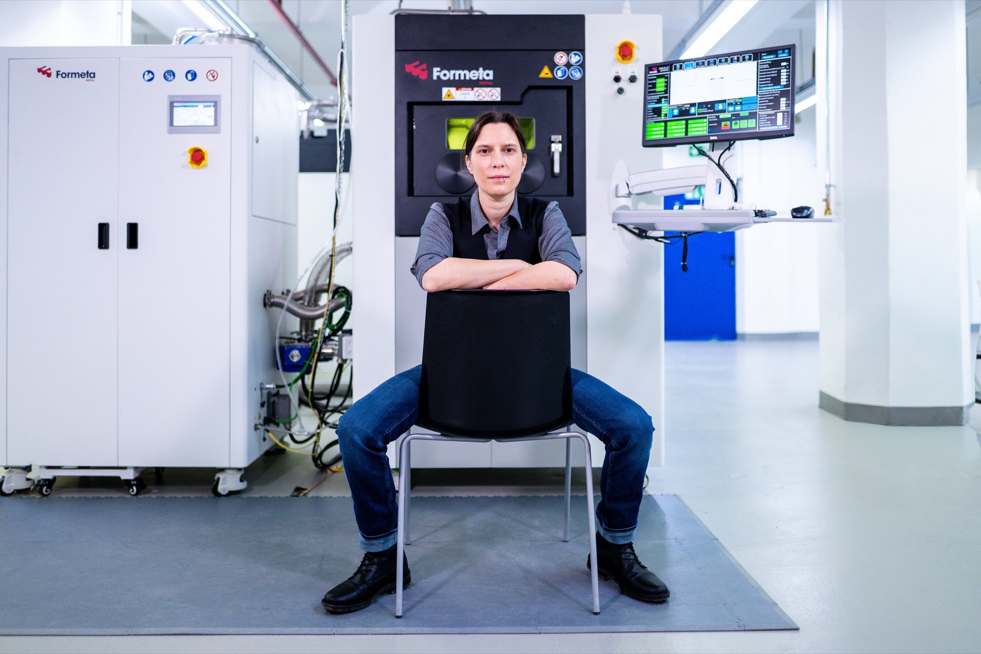 A team member at the Formeta 3D metal printer on the production floor